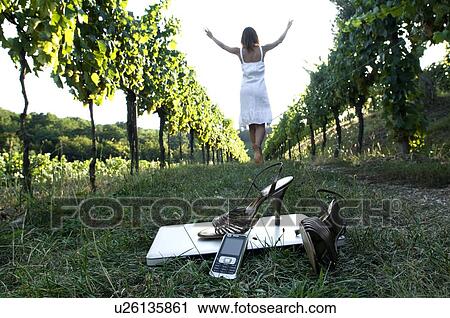 Young woman in vineyard with high heel shoes, mobile, and laptop in foreground View Large Photo Image Stock Image - Young woman in vineyard with high heel shoes, mobile, and laptop in foreground. Fotosearch
