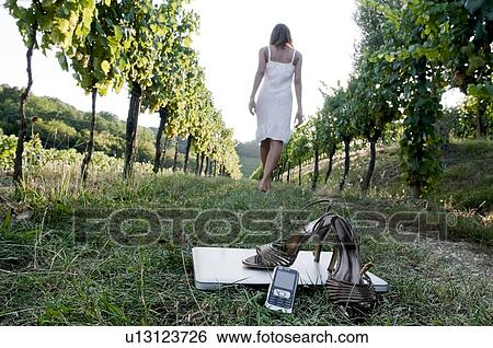 Young woman in vineyard with high heel shoes, mobile, and laptop in foreground View Large Photo Image Stock Photograph - Young woman in vineyard with high heel shoes, mobile, and laptop in foreground. Fotosearch