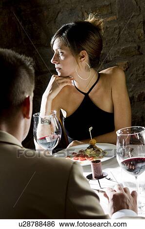 Young woman sitting at restaurant table with young man View Large Photo Image Stock Photograph - Young woman sitting at restaurant table with young man. Fotosearch