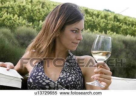 Young woman sitting in vineyard with white wine and a book View Large Photo Image Stock Photography - Young woman sitting in vineyard with white wine and a book. Fotosearch