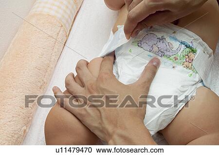 Young woman's hands changing baby's diaper View Large Photo Image Stock Image - Young woman's hands changing baby's diaper. Fotosearch