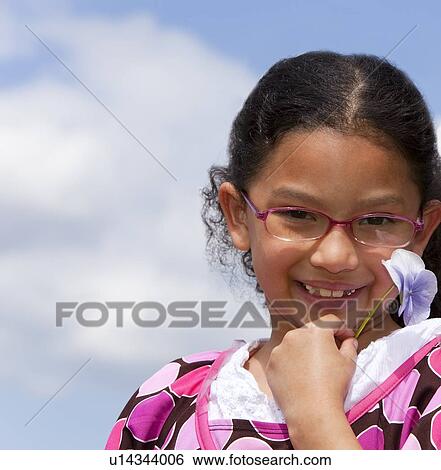 Stock Photograph - a girl holding a flower. Fotosearch