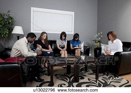 Stock Photograph - a group of people with their bibles praying together. Fotosearch