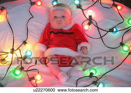 an infant girl in a christmas outfit surrounded by a string of lights View Large Photo Image Stock Image - an infant girl in a christmas outfit surrounded by a string of lights. Fotosearch