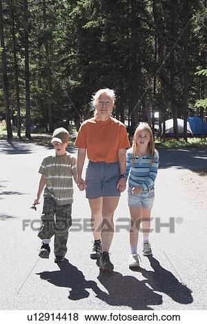 Stock Photo - banff national park, alberta, canada; a woman walks with a boy and girl in a campground. Fotosearch
