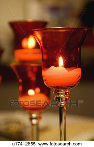 Stock Photography - candles lit in a glass candle holder. Fotosearch
