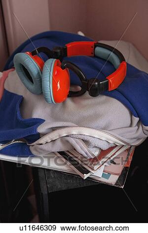 earphones on top of a pile of books and clothing View Large Photo Image Stock Photo - earphones on top of a pile of books and clothing. Fotosearch