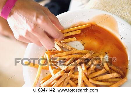 Stock Image - eating french fries with gravy. Fotosearch