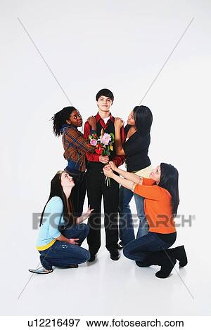 Stock Photo - girls surrounding a boy who is holding flowers. Fotosearch