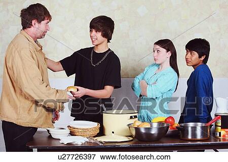 teenagers with differing attitudes serving a meal to a man View Large Photo Image Stock Photo - teenagers with differing attitudes serving a meal to a man. Fotosearch