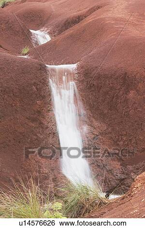 Stock Photograph - west kauai, hawaii; waterfalls on red rock at waimea canyon. Fotosearch