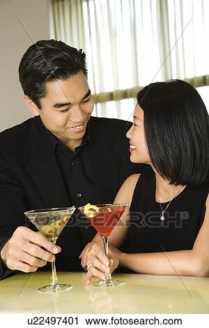 Stock Image - Attractive Young Couple With Cocktails Smiling. Fotosearch