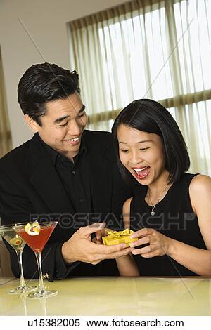 Stock Photography - Attractive Young Man Giving Gift to Woman. Fotosearch