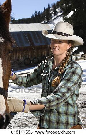 Stock Photography - Attractive Young Woman Petting Horse. Fotosearch