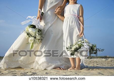 Stock Image - Bride and Flower Girl on Beach. Fotosearch