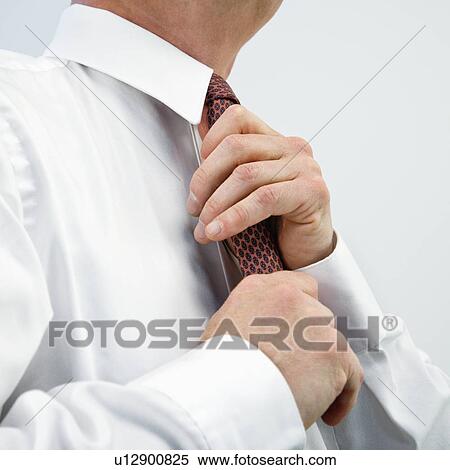 Businessman fixing tie View Large Photo Image Stock Photography - Businessman fixing tie. Fotosearch