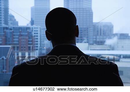 Stock Image - Businessman Looking Out of Window. Fotosearch