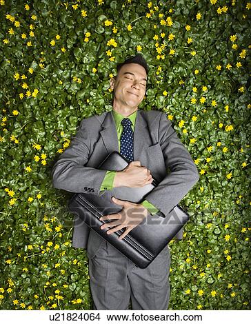 Picture - Businessman Lying in Flower Patch. Fotosearch