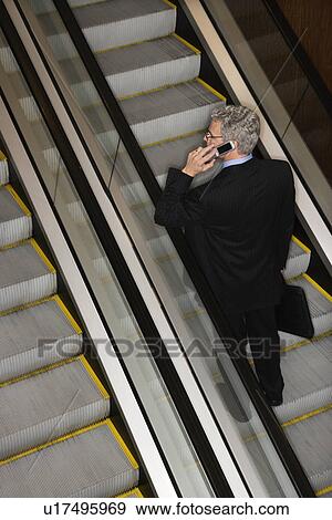 Businessman on Escalator with Cellphone View Large Photo Image Stock Photo - Businessman on Escalator with Cellphone. Fotosearch