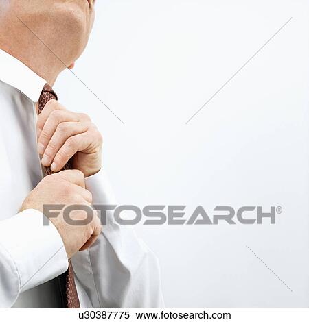 Stock Photography - Businessman tying necktie. Fotosearch