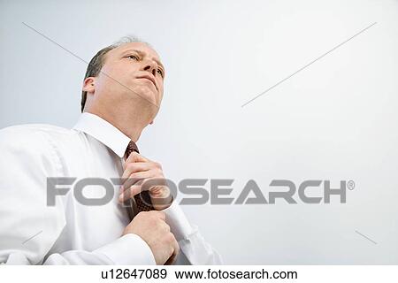 Businessman tying tie View Large Photo Image Stock Photo - Businessman tying tie. Fotosearch