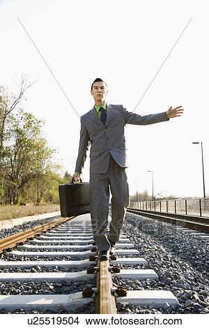 Businessman Walking on Railroad Tracks View Large Photo Image Picture - Businessman Walking on Railroad Tracks. Fotosearch