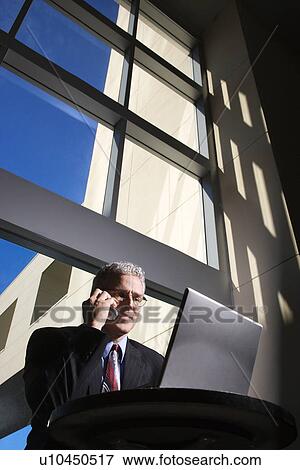 Businessman with Laptop Computer and cell phone View Large Photo Image Stock Photo - Businessman with Laptop Computer and cell phone. Fotosearch