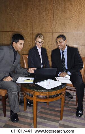 Stock Image - Businesspeople Looking at Laptop. Fotosearch