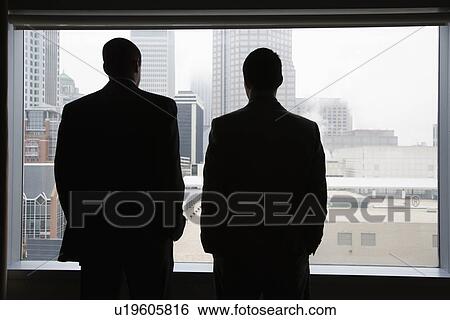 Stock Photograph - Businesspeople Looking Out of a Window. Fotosearch