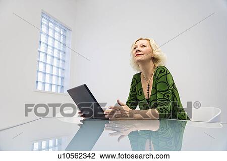 Stock Image - Businesswoman at desk. Fotosearch