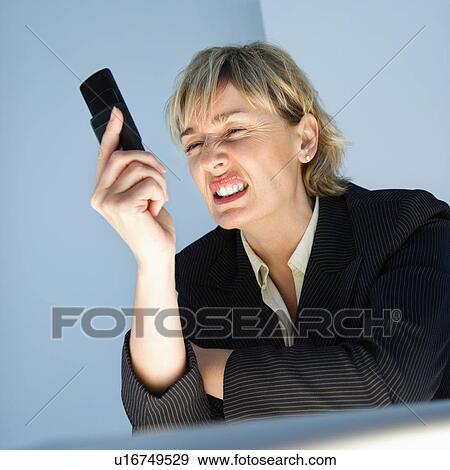 Stock Photo - Businesswoman frustrated with cellphone. Fotosearch