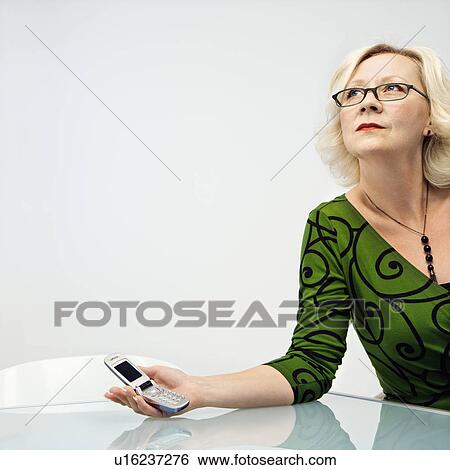 Stock Photograph - Businesswoman holding mobile phone. Fotosearch
