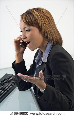 Stock Image - Businesswoman on cellphone. Fotosearch