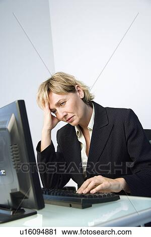 Stock Image - Businesswoman rubbing head.. Fotosearch