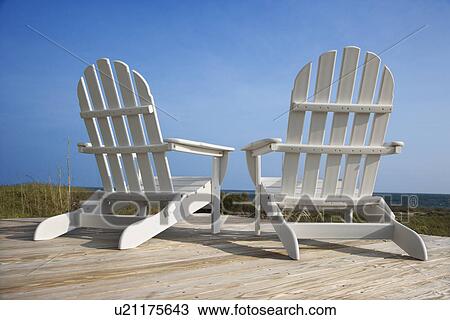Stock Image - Chairs on Deck Facing Ocean. Fotosearch