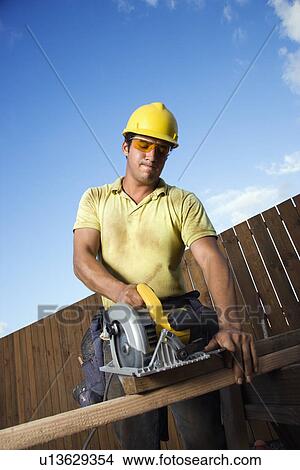 Picture - Construction Worker Cutting Wood. Fotosearch