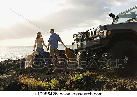 Stock Photograph - Couple and Dogs at the Beach. Fotosearch