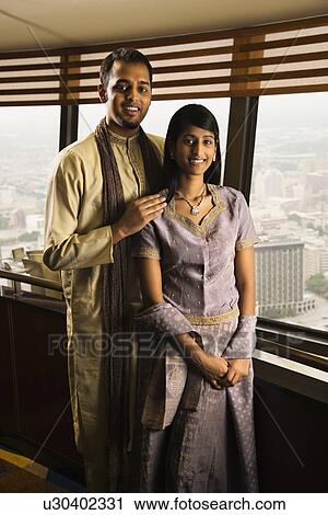 Stock Image - Couple By High Rise Windows. Fotosearch