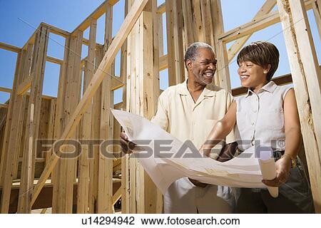 Couple Holding Building Plans on Construction Site View Large Photo Image Stock Image - Couple Holding Building Plans on Construction Site. Fotosearch