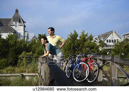 Couple on bridge with bicycles View Large Photo Image Stock Image - Couple on bridge with bicycles. Fotosearch
