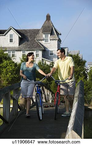 Stock Photo - Couple on bridge with bicycles. Fotosearch