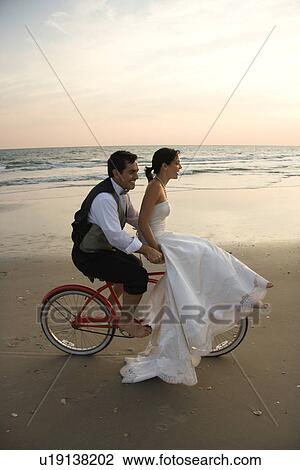 Couple Riding Bike on Beach View Large Photo Image Stock Image - Couple Riding Bike on Beach. Fotosearch