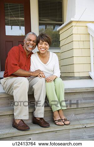 Picture - Couple Sitting on Outdoor Steps of Home Smiling. Fotosearch