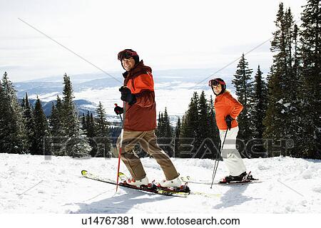 Stock Image - Couple Skiing on Mountain Slope. Fotosearch