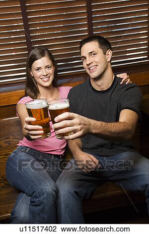 Stock Image - Couple Toasting Their Beers. Fotosearch