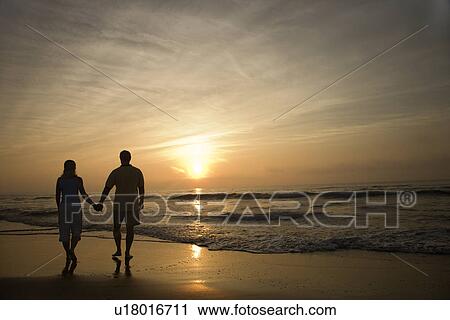 Couple Walking on Beach at Sunset View Large Photo Image Stock Image - Couple Walking on Beach at Sunset. Fotosearch