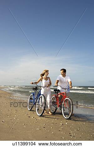 Picture - Couple with Bikes at the Beach. Fotosearch