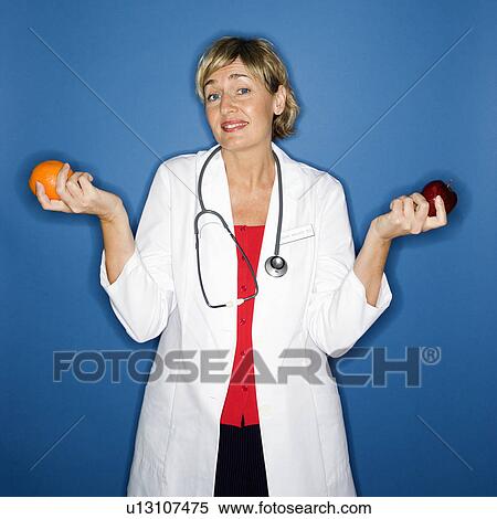 Stock Photography - Doctor holding fruit. Fotosearch