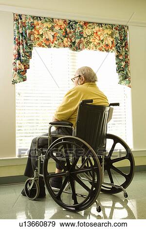 Stock Photo - Elderly Man in Wheelchair by Window. Fotosearch