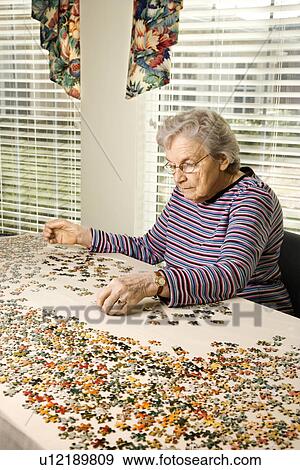 Stock Photo - Elderly Woman Doing Jig Saw Puzzle. Fotosearch